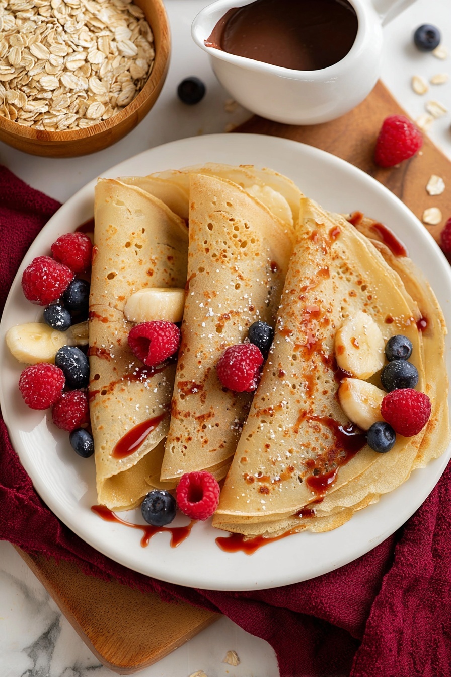 Healthy Oat Flour Crepes, healthy crepes recipe, easy oat flour crepes, nutritious breakfast ideas, quick healthy breakfast - Three thin, golden-brown crepes are folded and placed slightly overlapping on a white plate. The crepes have a smooth texture with small air bubbles visible. Scattered on top and around the crepes are small pieces of light yellow banana, bright red raspberries, and dark blue blueberries. A shiny, red syrup is drizzled over the crepes and fruit, pooling slightly on the plate. In the background, there is a small white jug filled with thick chocolate sauce and a wooden bowl of light tan rolled oats on a wooden surface, all set against a white marbled texture. A deep red cloth is partially visible on the left side of the image. photo taken with an iphone --ar 2:3 --v 7