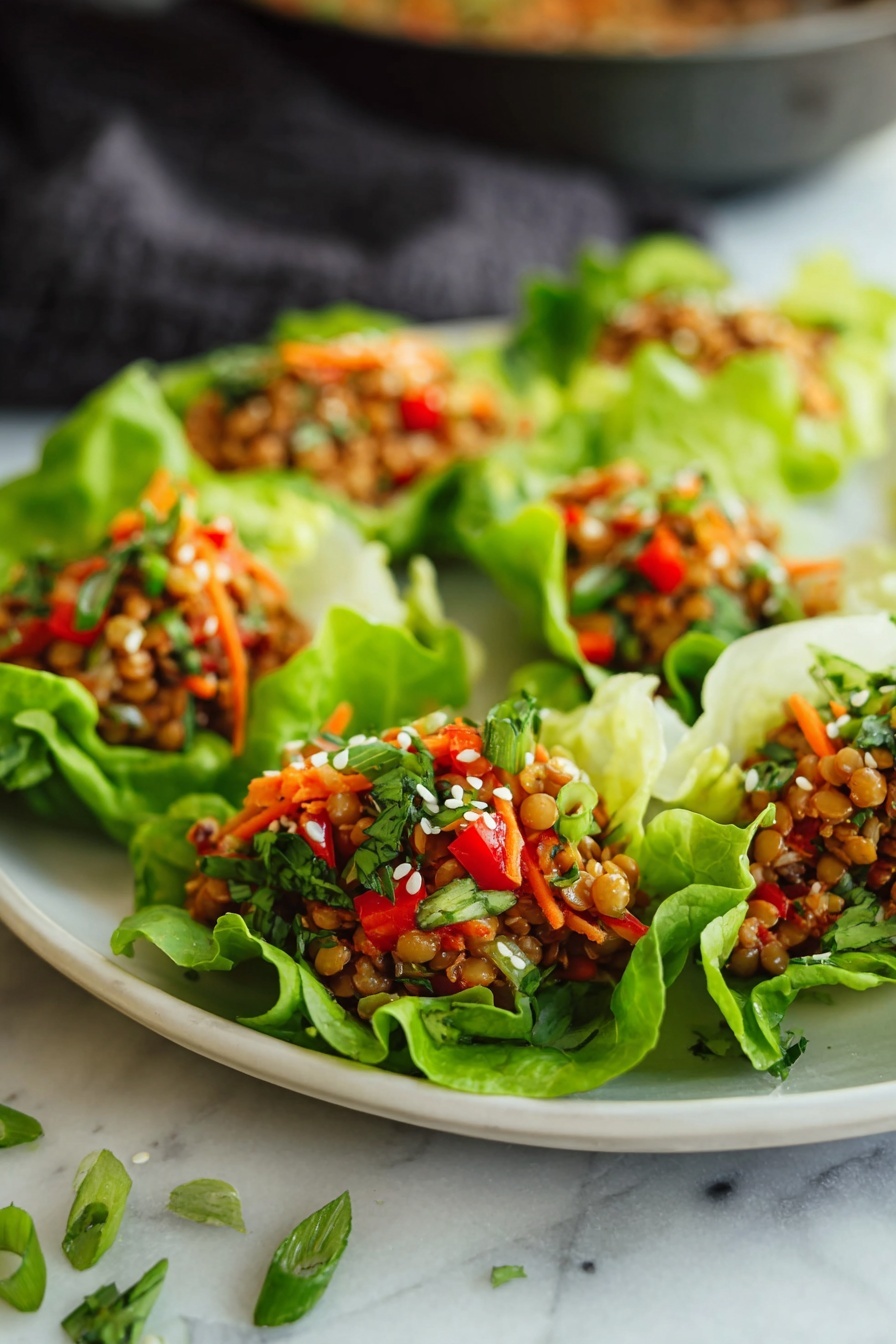 Asian Lentil Lettuce Wraps, healthy Asian lettuce wraps, vegan lentil wraps, quick vegetarian appetizer, flavorful lettuce wraps - A white plate holds seven lettuce cups arranged in a circular pattern on a white marbled surface. Each cup has bright green lettuce leaves forming a bowl shape, filled with a mixture of orange lentils, small chopped red bell peppers, shredded orange carrots, and small green onion pieces, topped with white sesame seeds. To the top left is a black pan, showing more of the lentil mixture, and to the top right are two bottles, one dark with a yellow label and the other red with white text. Green onions and cilantro sprigs lie scattered around the plate, and a gray knit cloth is visible on the right side. photo taken with an iphone --ar 2:3 --v 7