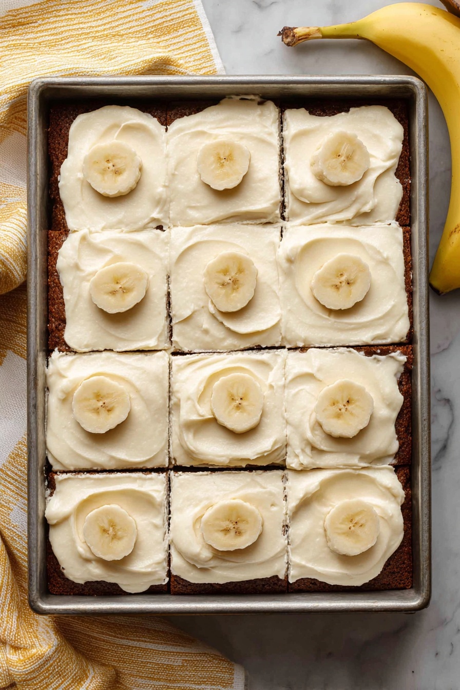 Easy Banana Cake with Cream Cheese Frosting, moist banana cake, quick banana dessert, homemade banana cake recipe, simple frosting for cakes - A rectangular metal baking pan holds a banana cake cut into twelve square pieces, arranged in three rows and four columns. The cake has a dark brown base layer with a smooth, creamy off-white frosting spread evenly on top, featuring gentle swirls. Five of the squares have one or two thin banana slices neatly placed in the center, adding light yellow color with slightly darker spots. The pan is set on a white marbled surface with a yellow-striped cloth and a whole banana partly visible nearby. photo taken with an iphone --ar 2:3 --v 7